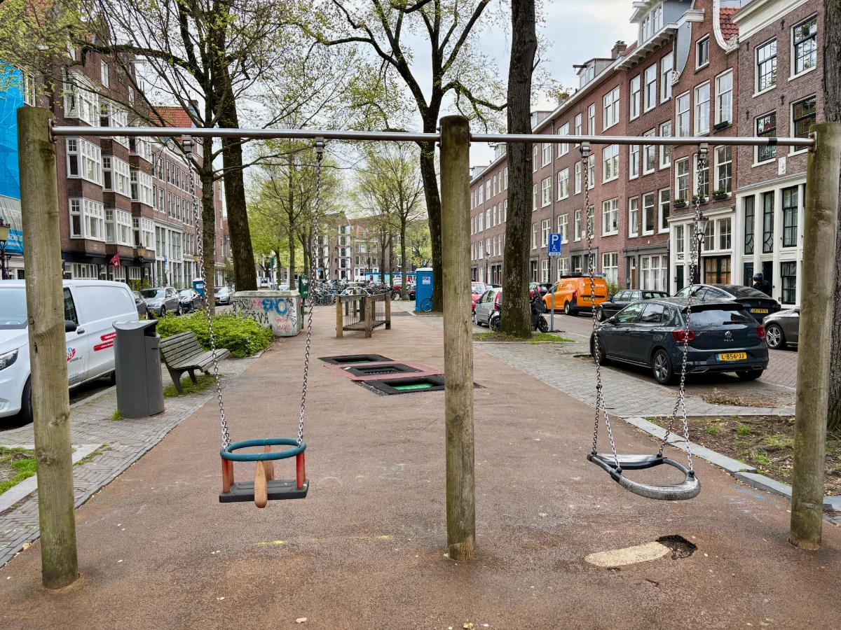 Simple wooden swing set with regular swing and baby swing on small residential playground