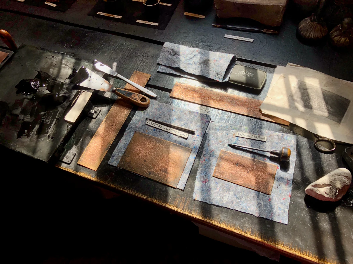 Sunlight hitting a table with antique tools used for etching
