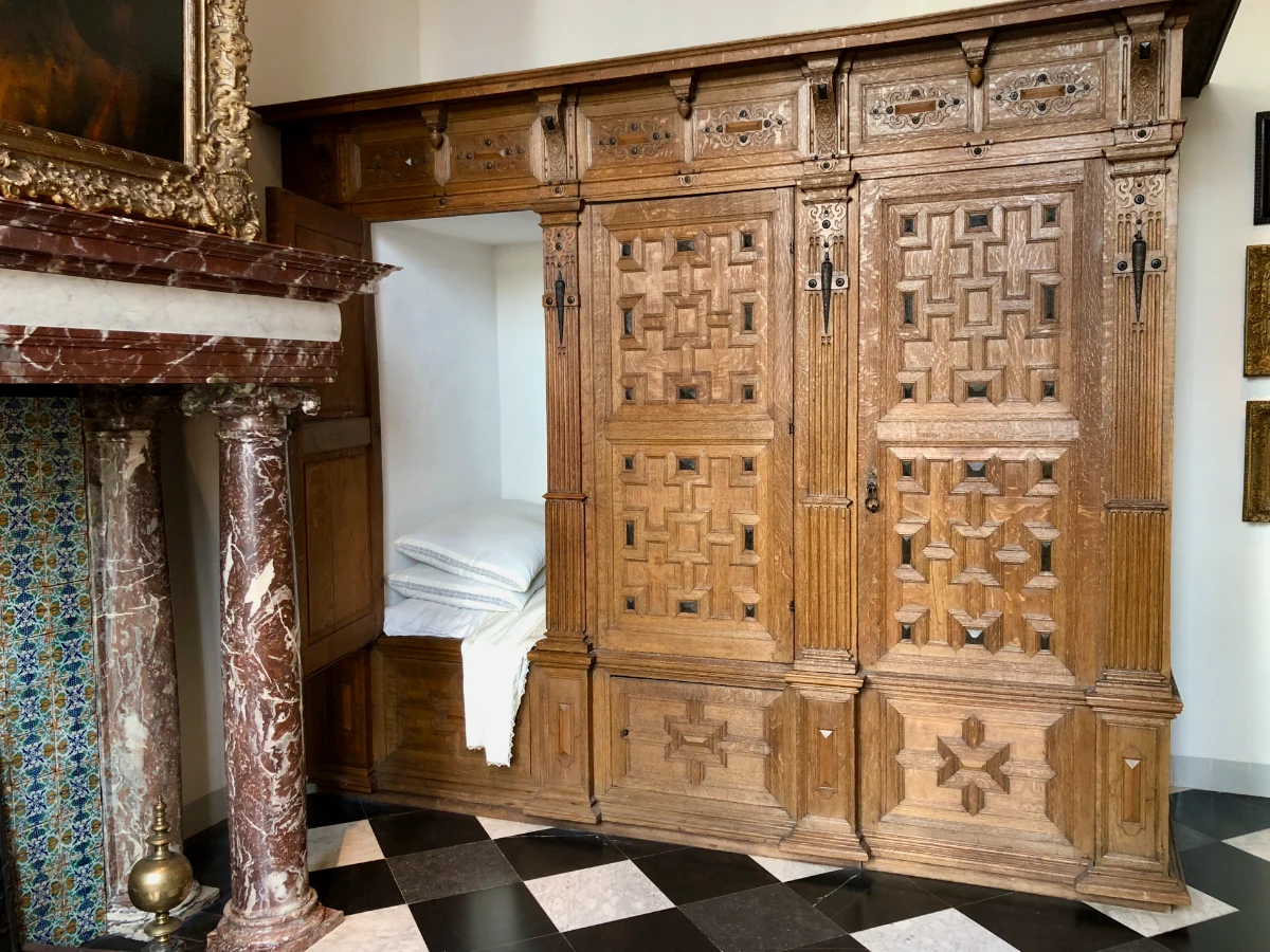 Historic Dutch home with ornate bed box and marble fireplace