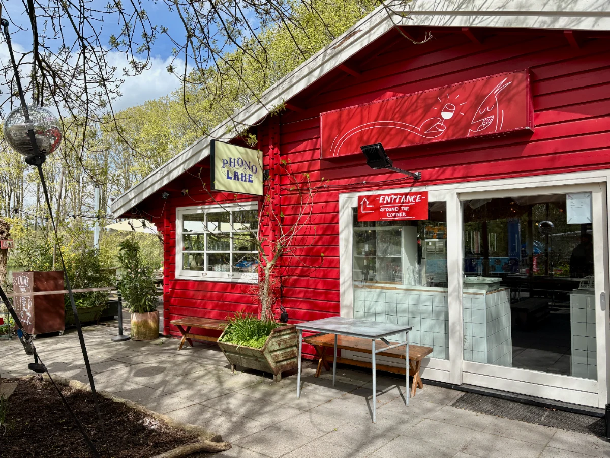 Bright red painted building with large windows with trees and disco ball decoration