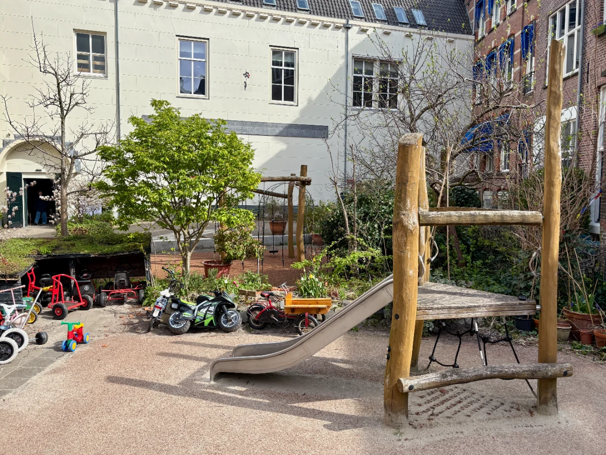 Climbing structure with slide and small shed with lots of kids bikes