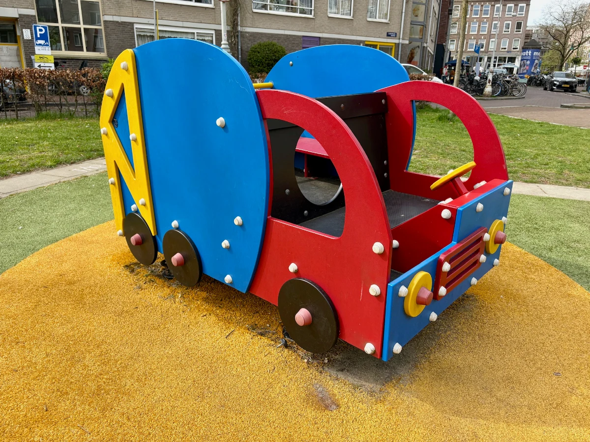 Red, blue, and yellow toddler-sized truck on a playground